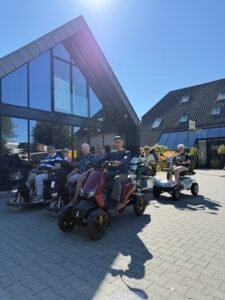 Deelnemers van Scootstersclub Houten staan met hun scootmobielen klaar voor vertrek bij ’t Bouwhuys